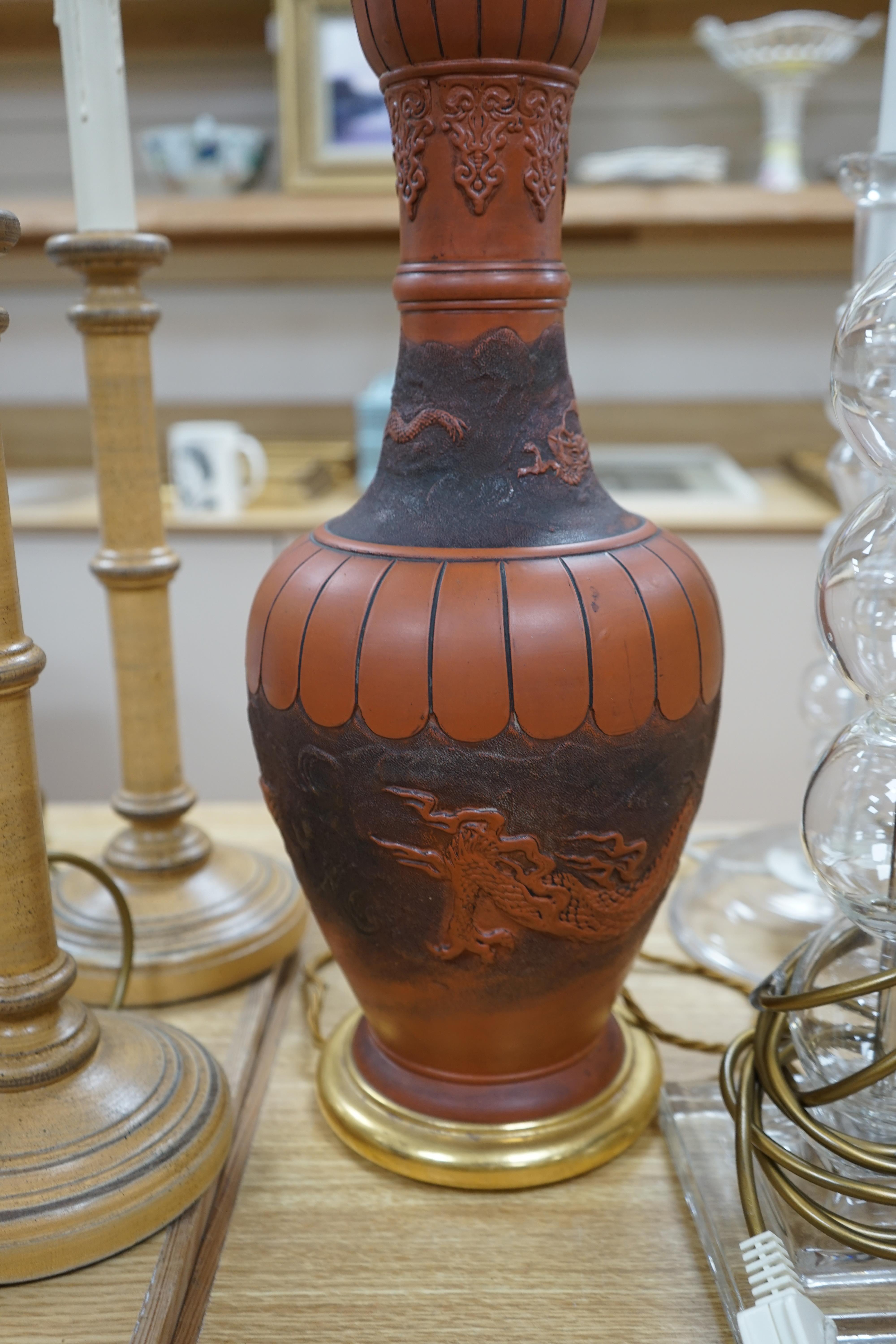 A Japanese terracotta dragon lamp base, two glass and a pair of wooden candlestick lamp bases, tallest 77cm high including light fitting (5). Condition - fair to good